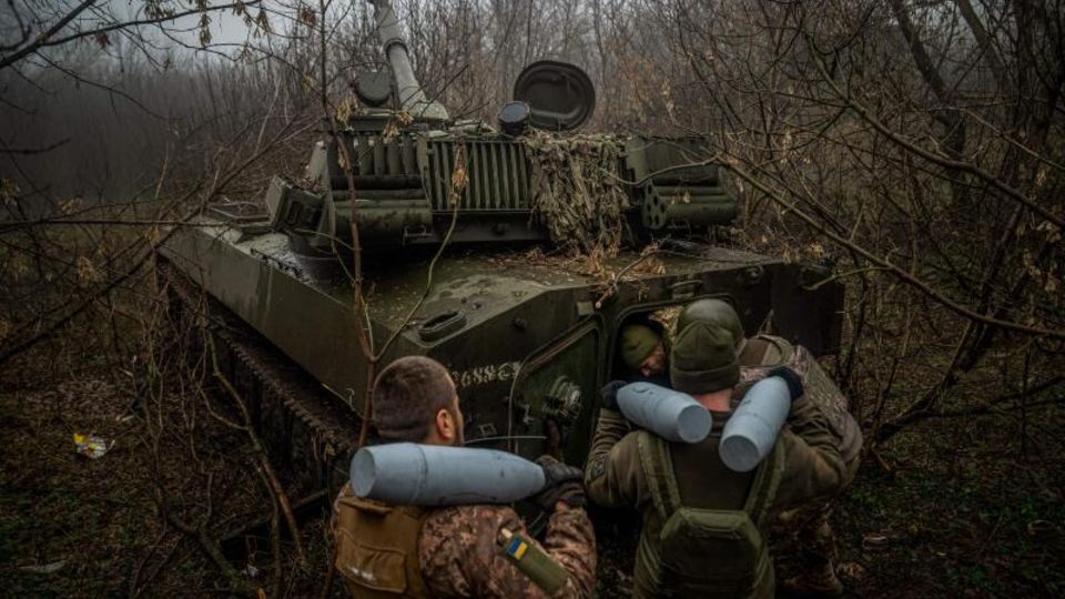 Ukrainische Soldaten laden Munition in eine Panzerhaubitze 