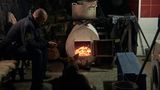 Nothelfer wärmt sich mit Hund an einem Holzofen auf