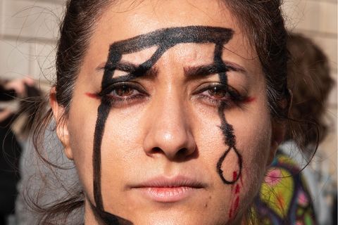 Eine Frau demonstriert in Barcelona gegen die Hinrichtung des Rappers Mohsen S. im Iran.