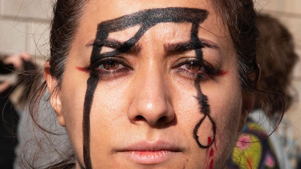 Eine Frau demonstriert in Barcelona gegen die Hinrichtung des Rappers Mohsen S. im Iran.