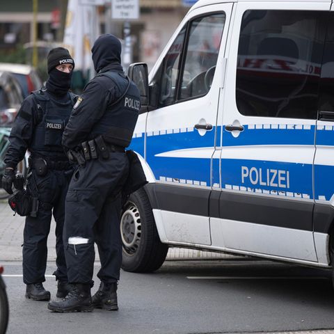 Polizisten vor Dienstwagen