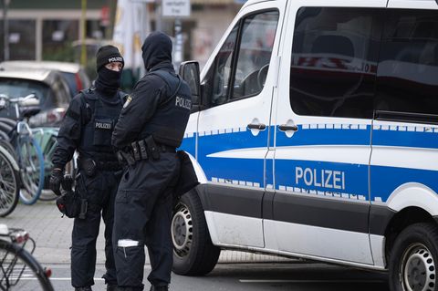 Polizisten vor Dienstwagen