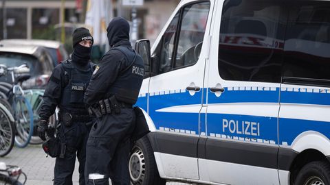 Polizisten vor Dienstwagen
