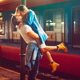 Ein Paar küsst sich am Bahnsteig.