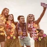 Vier Freunde machen auf Hawaii ein Selfie mit dem Smartphone.
