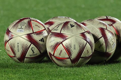 WM 2022: "Al Hilm"-Spielbälle liegen auf dem grünen Rasen eines Trainingsplatzes