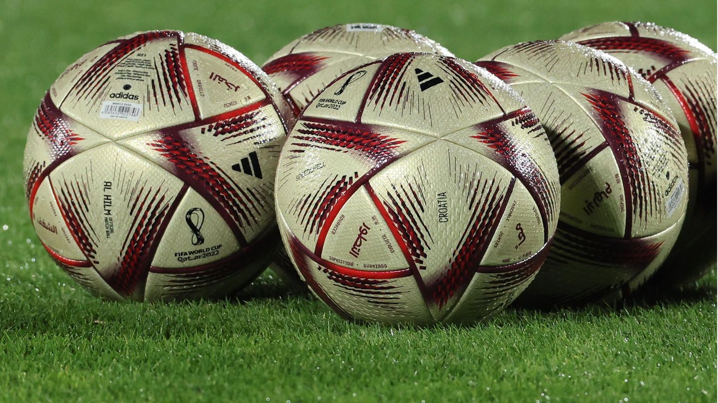 WM 2022: "Al Hilm"-Spielbälle liegen auf dem grünen Rasen eines Trainingsplatzes