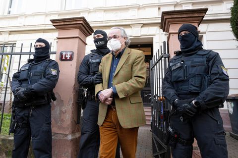 Polizisten führen Heinrich XIII Prinz Reuß zu einem Polizeifahrzeug