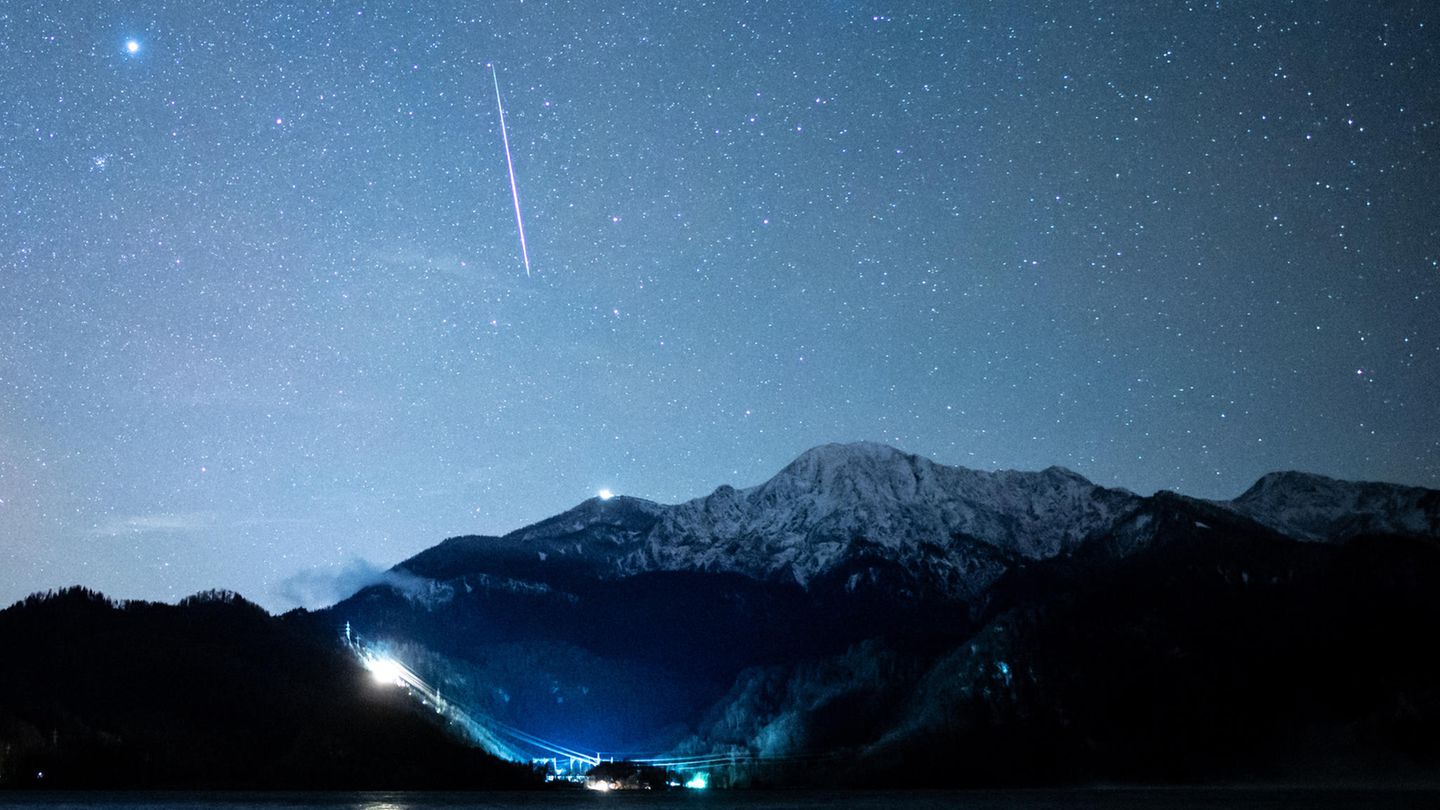 Eine Sternschnuppe ist während der Geminiden über dem Kochelsee in Bayern zu sehen