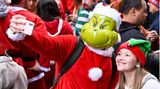 Ein als Grinch verkleideter Mann macht ein Selfie mit einer Frau