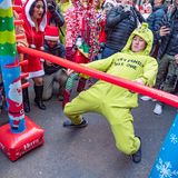 Teilnehmer der SantaCon-Parade tanzen Limbo