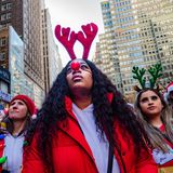 Eine Gruppe junger Frauen mit Rentier-Haarreifen und Weihnachtsmann-Mützen