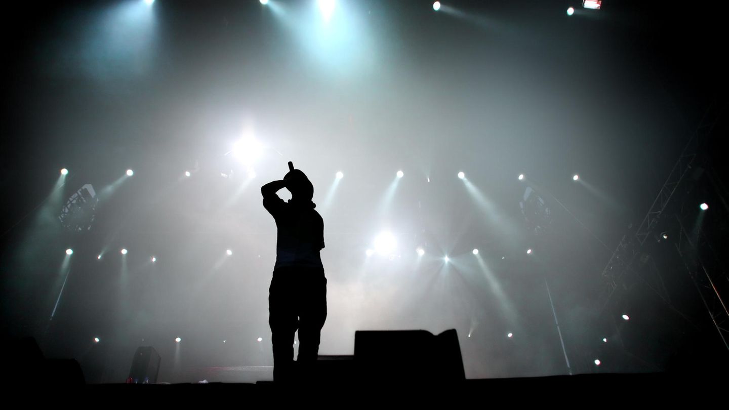 Ein Rapper steht auf einer Bühne.