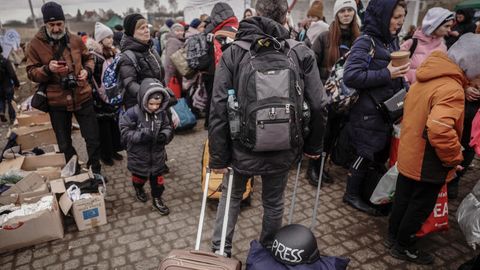Ein Journalist mit Schutzhelm im Gepäck an der ukrainisch-polnischen Grenze.