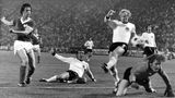 Das Team der Bundesrepublik ist amtierender Europameister, als es in der Gruppenphase der WM 1974 auf die Mannschaft der DDR trifft. Am 22. Juni trifft Jürgen Sparwasser (l.) in der 77. Spielminute zum 1:0 für die DDR. In den Gesichtern von Torwart Sepp Maier (r.) und Verteidiger Horst-Dieter Höttges (am Boden) steht blankes Entsetzen. Am Ende wird die DDR vor der BRD Gruppensieger. In der zweiten Runde kassiert die DDR dann Niederlagen gegen Brasilien und die Niederlande, schafft aber ein 1:1 gegen Argentinien – zu wenig für das Erreichen des Halbfinales.  Die BRD gewinnt alle folgenden Spiele und wird im Finale gegen die Niederlande Weltmeister. Trotzdem ist die Erinnerung an die Niederlage gegen die DDR heute in ganz Deutschland präsenter als der Titelgewinn.