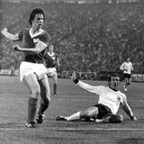 Das Team der Bundesrepublik ist amtierender Europameister, als es in der Gruppenphase der WM 1974 auf die Mannschaft der DDR trifft. Am 22. Juni trifft Jürgen Sparwasser (l.) in der 77. Spielminute zum 1:0 für die DDR. In den Gesichtern von Torwart Sepp Maier (r.) und Verteidiger Horst-Dieter Höttges (am Boden) steht blankes Entsetzen. Am Ende wird die DDR vor der BRD Gruppensieger. In der zweiten Runde kassiert die DDR dann Niederlagen gegen Brasilien und die Niederlande, schafft aber ein 1:1 gegen Argentinien – zu wenig für das Erreichen des Halbfinales.  Die BRD gewinnt alle folgenden Spiele und wird im Finale gegen die Niederlande Weltmeister. Trotzdem ist die Erinnerung an die Niederlage gegen die DDR heute in ganz Deutschland präsenter als der Titelgewinn.