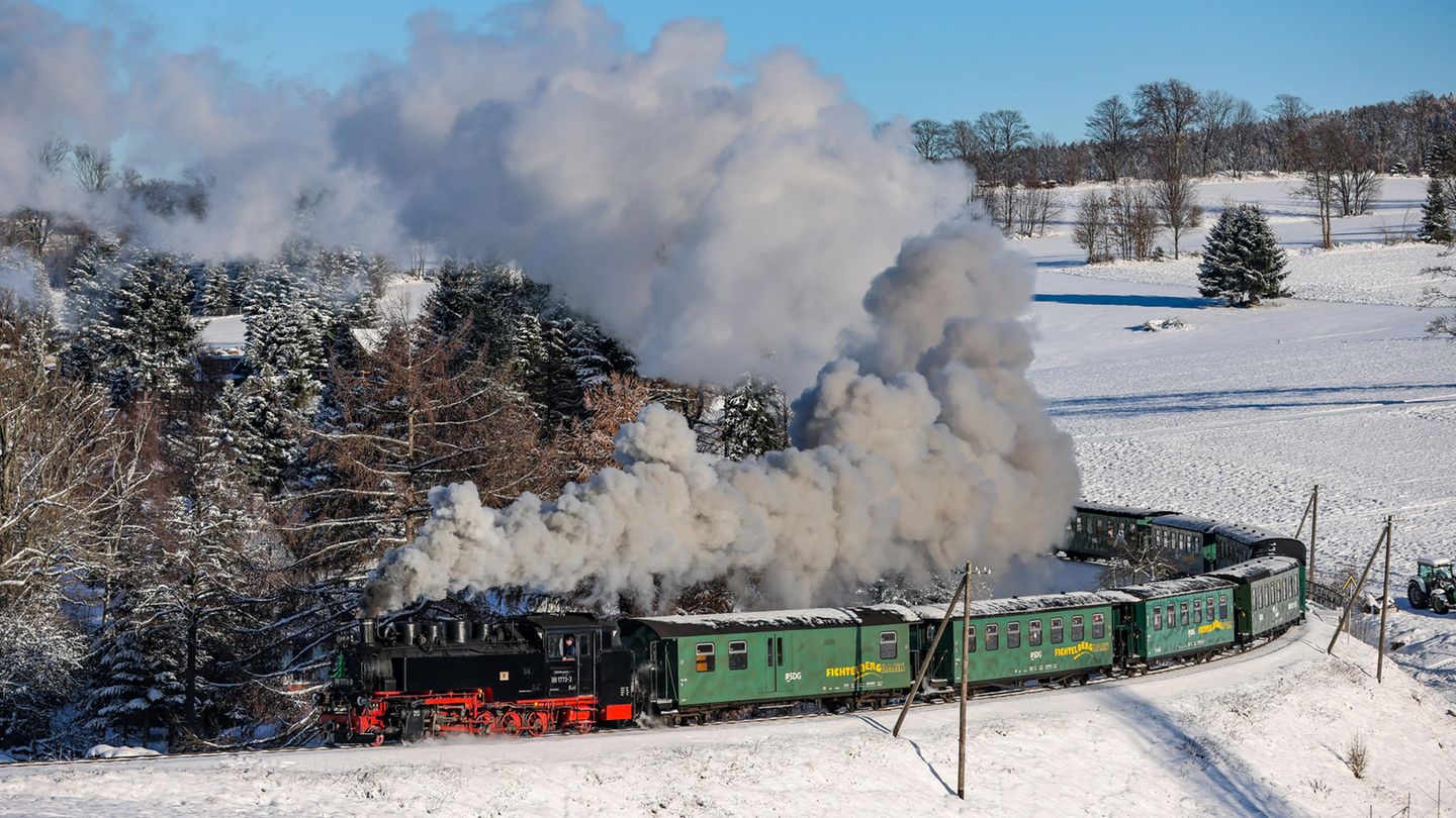 Die Fichtelbergbahn bahnt sich ihren Weg durch den verschneiten Winterwald im sächsischen Erzgebirge.