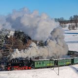 Die Fichtelbergbahn bahnt sich ihren Weg durch den verschneiten Winterwald im sächsischen Erzgebirge.