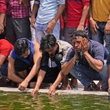 Männer kühlen sich mit Wasser ab