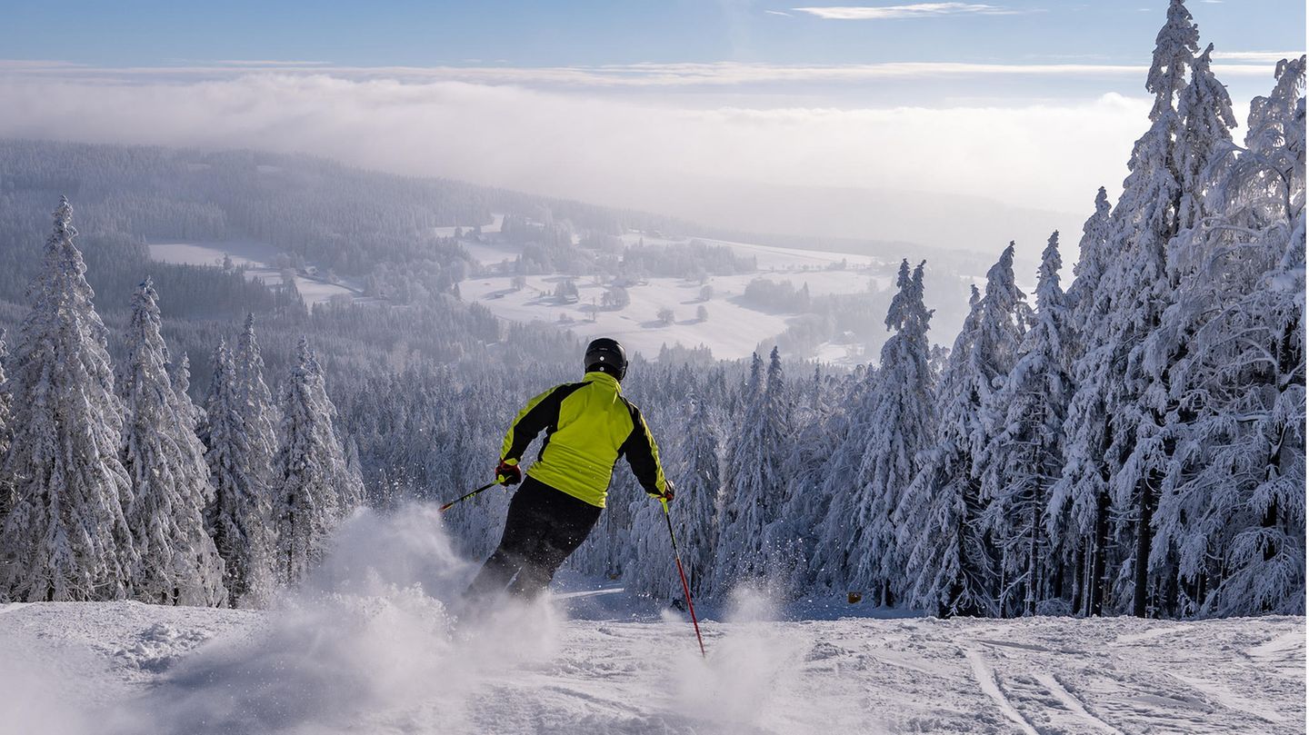 Ein Skifahrer gleitet im tschechischen Adlergebirge einen Hang hinunter ins Tal