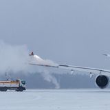 Ein Mitarbeiter des Nürnberger Albrecht Dürer Airports besprüht einen Airbus A350 mit Enteisungsmittel