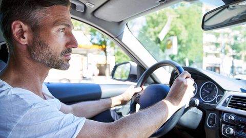 Ein Mann sitzt am Steuer eines Autos
