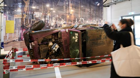 Ein umgestürzter und zerstörter Jeep liegt hinter Absperrband in einer Ausstellung des Berliner Technikmuseums