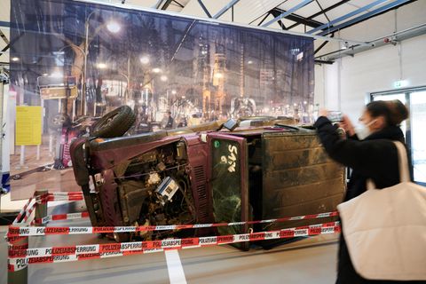 Ein umgestürzter und zerstörter Jeep liegt hinter Absperrband in einer Ausstellung des Berliner Technikmuseums