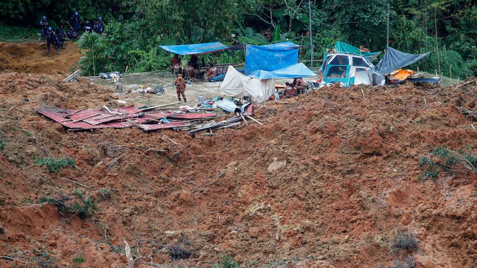 Rettungsteams suchen nach der Erdrutsch die vermissten Personen