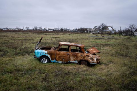 Ein beschossenes Auto steht auf einem Feld bei Cherson