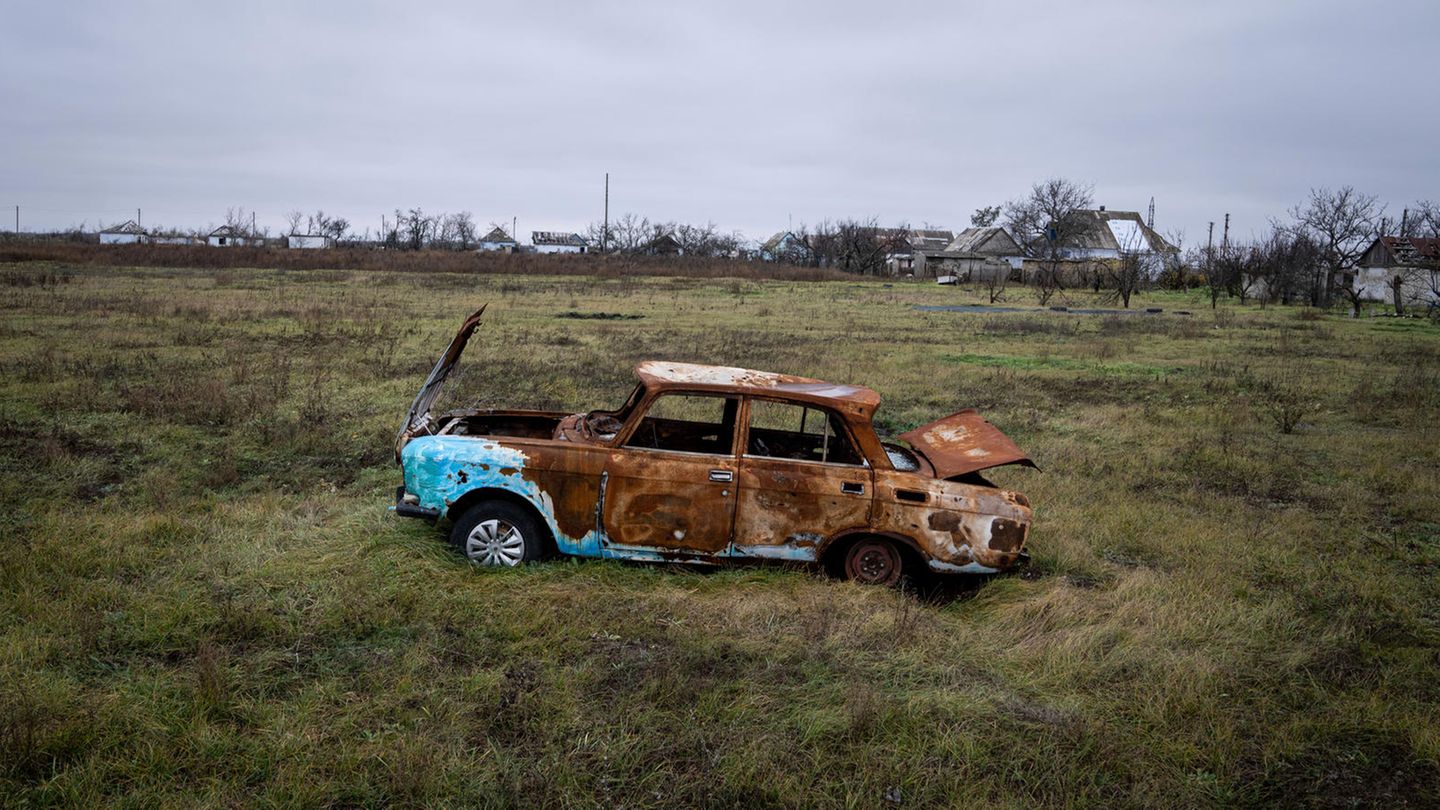 Ein beschossenes Auto steht auf einem Feld bei Cherson