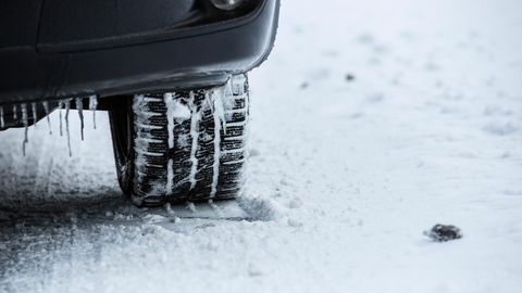 Autoreifen steht auf eingeschneitem Boden