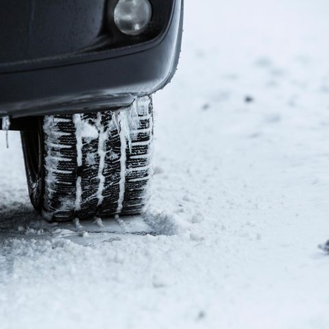 Autoreifen steht auf eingeschneitem Boden