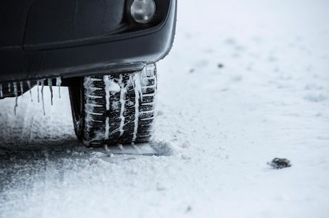 Autoreifen steht auf eingeschneitem Boden