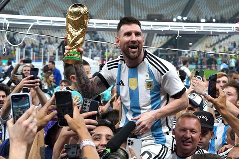 Lionel Messi feiert mit dem WM-Pokal