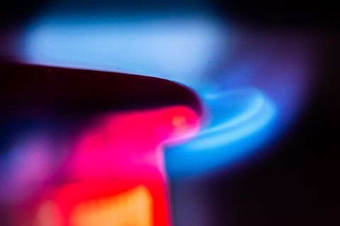 Aus dem Brenner eines Gasherdes schlagen blaue Flammen