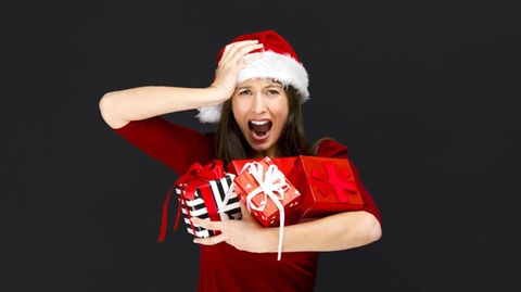 Eine Frau hält verzweifelt ihre Geschenke in der Hand.