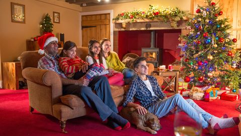 Familie sitzt an Weihnachten vor dem TV