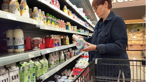 Frau begutachtet Joghurt-Produkte im Supermarkt