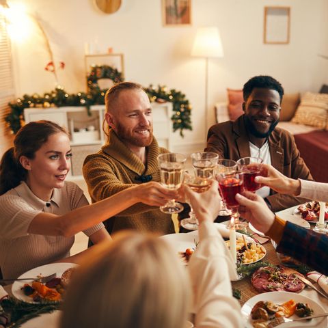Freunde sitzen versammelt an Weihnachten um den Tisch