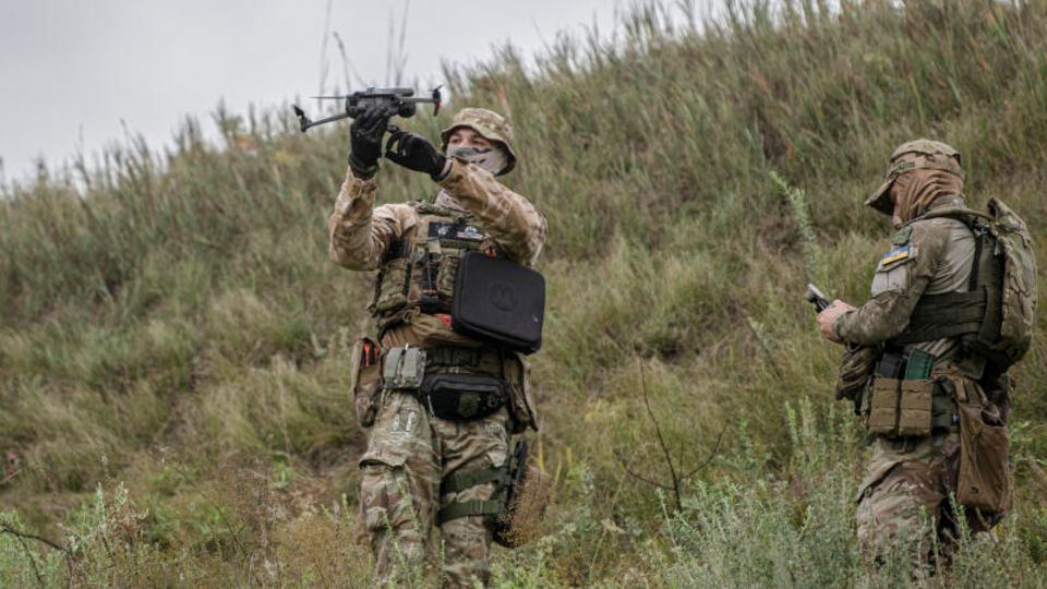 Ein ukrainischer Soldat hält auf einem Truppenübungsplatz eine Drohne hoch