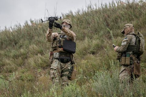 Ein ukrainischer Soldat hält auf einem Truppenübungsplatz eine Drohne hoch