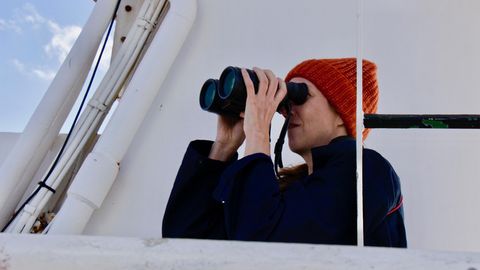 Sina Horsthemke auf dem Peildeck mit Fernglas