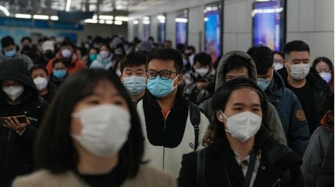 China, Peking: Pendler mit Schutzmasken