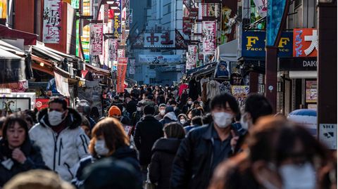 Viele Menschen gehen auf einer Einkaufsstraße in Japan entlang