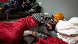 USA, Canton: Thomas Dameron umarmt seinen drei Monate alten Welpen Rello in einer Notunterkunft für Obdachlose in der Action Church, während einer Kältewelle in den USA. Dameron, seine Frau und sein Hund leben in ihrem Auto, suchten aber eine Unterkunft, als der Motor ausfiel und sie sich nicht mehr warm halten konnten. Die Kirche öffnet sich für Obdachlose, wenn die Temperaturen unter den Gefrierpunkt fallen, und stellt Feldbetten, Decken und Mahlzeiten zur Verfügung, die von örtlichen Unternehmen gespendet werden.
