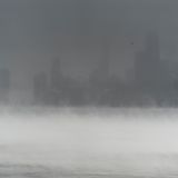 USA, Chicago: Die Skyline der Innenstadt von Chicago wird von Schneeverwehungen und Dampf verdeckt, der vom Lake Michigan aufsteigt, gesehen vom Montrose Harbor aus. 