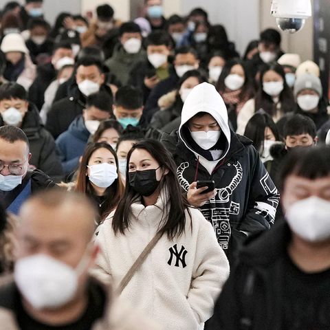 Menschen gehen durch eine U-Bahn-Station in Peking.