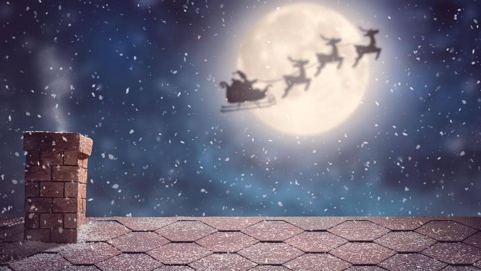 Ein Weihnachtsmann mit seinem Schlitten im Anflug auf ein Haus