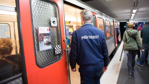 Ein Fahrenkartenkontrolleur steigt in eine Bahn